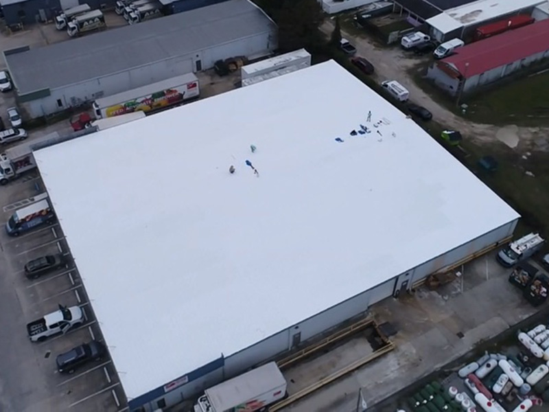 Aerial view of a commercial rooftop with newly applied Inland Coating by Total Roofing Solutions & Construction