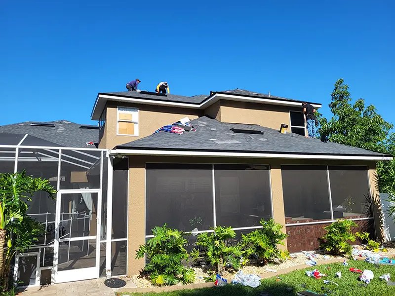 Crew installing new shingles on home