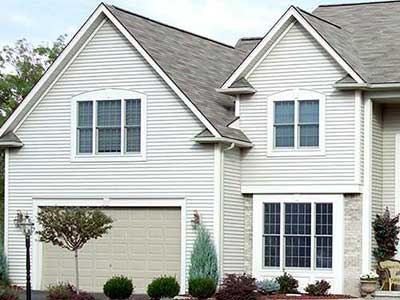 Front view of mid-class home with white Norandex siding