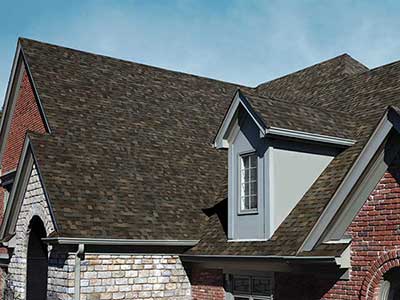 Side view of a mid-sized residential roof with dark brown Owens Corning shingles
