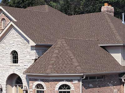 Front view of a higher-end home with brown Tamko shingles on its roof